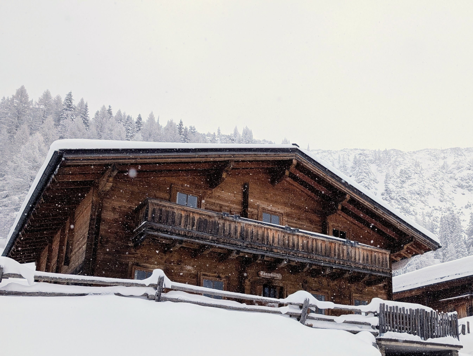 verschneite Felserhütte mit Sonne im Hintergrund